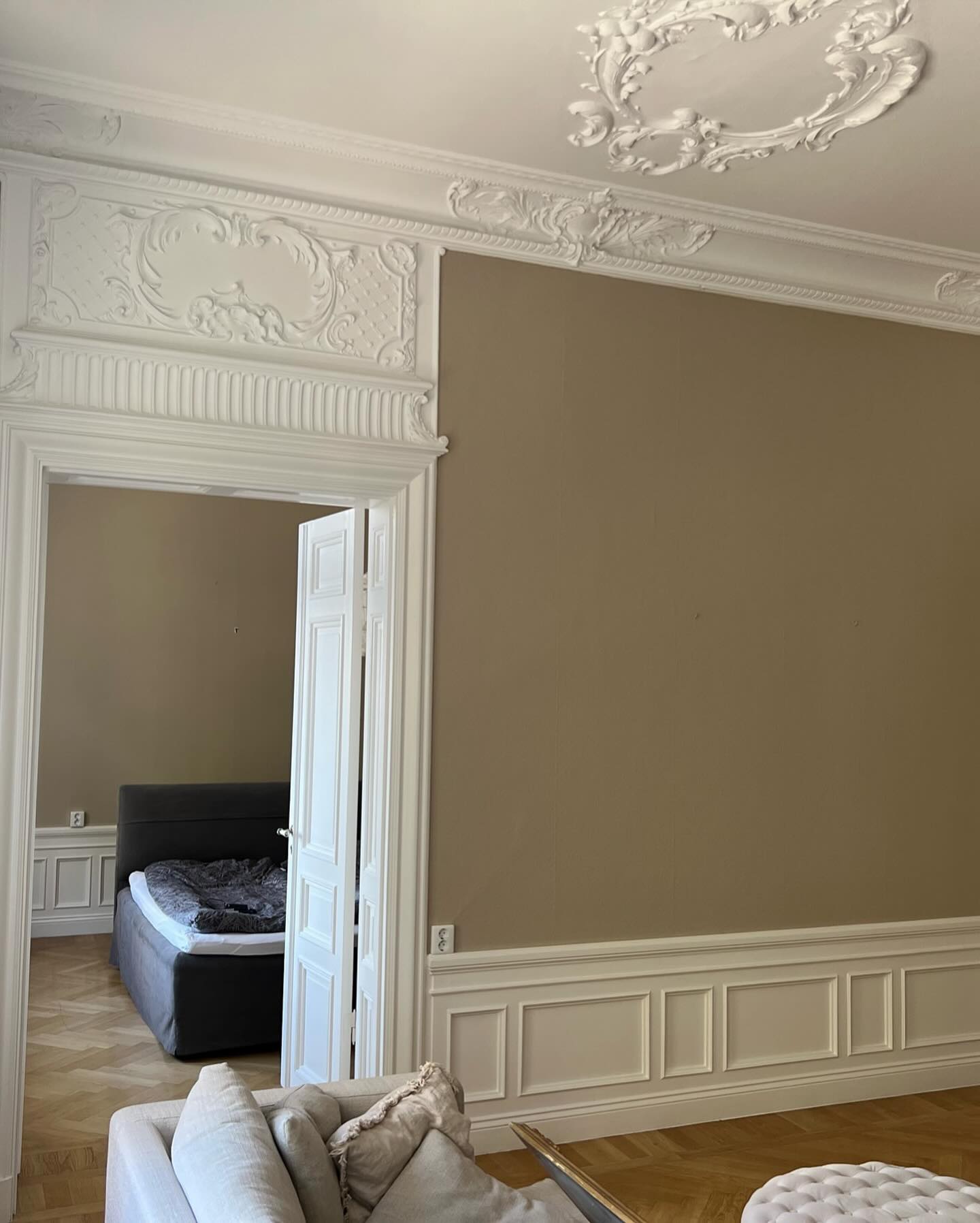 Stuckatur över dörr och beige vägg efter målning