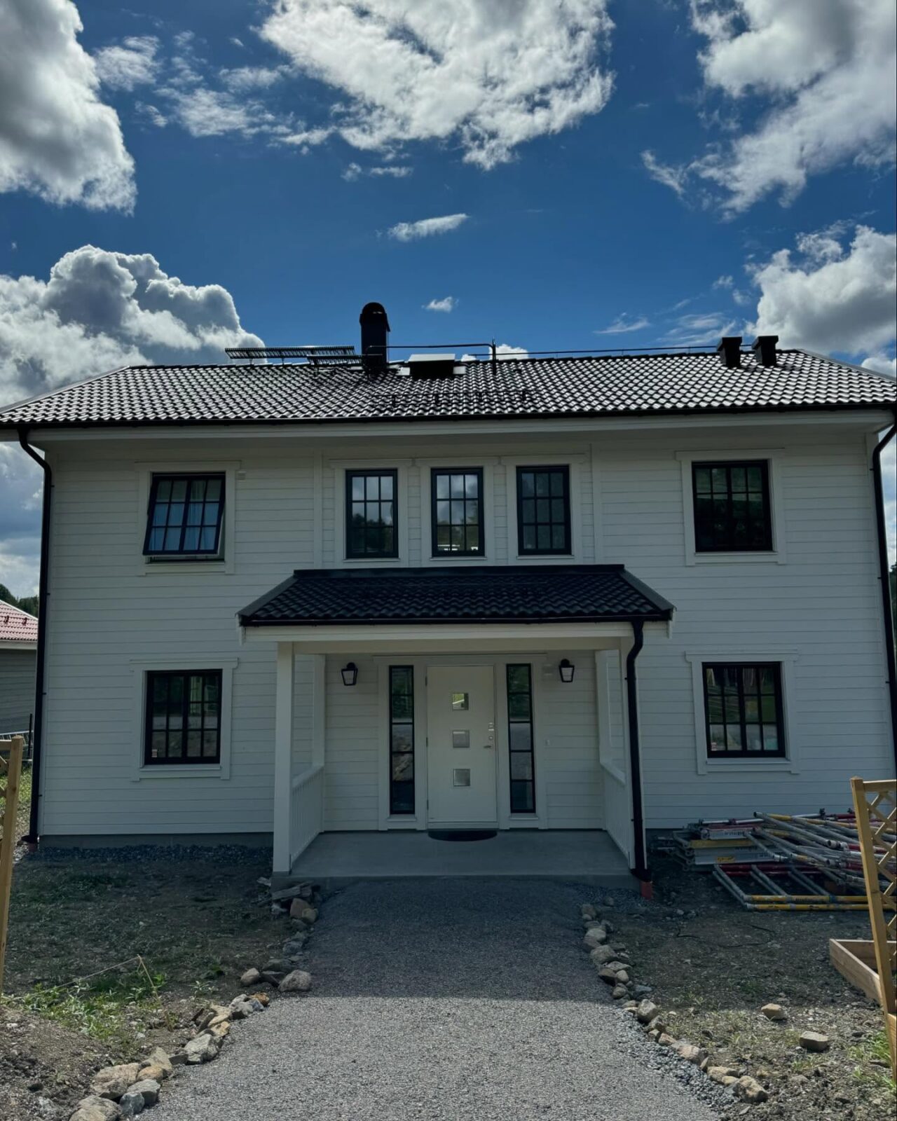 Nymålat vitt hus med svarta fönster, framsidan