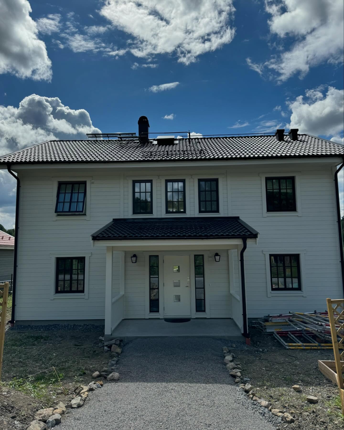 Nymålat vitt hus med svarta fönster, framsidan