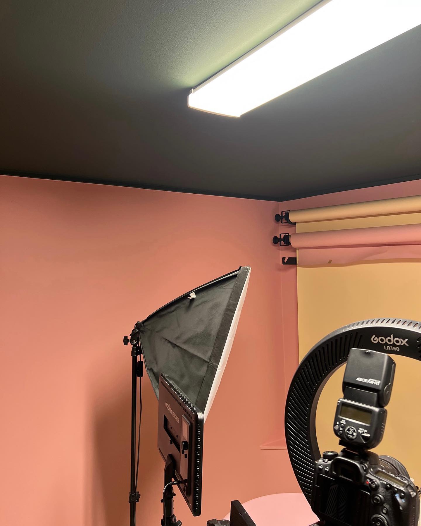 Hörn med rosa väggar och mörkt tak, med fotobelysning och bakgrundsrullar framför